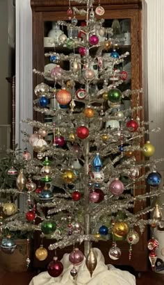 a silver christmas tree with ornaments on it