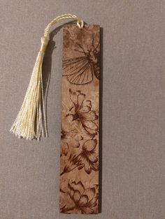 a bookmark with a tassel hanging from it's side on a table