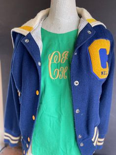 Step back in time with this stylish Vintage Varsity Jacket in vibrant blue and gold. Perfect for showcasing classic collegiate spirit, this retro athletic bomber jacket captures the essence of 1980s sports culture. It's not just a piece of clothing, but a slice of history. - Timeless Style: Features the iconic letterman design with striped ribbing and a snap front closure. - Vibrant Colors: Stand out with the striking blue and gold colorway, perfect for any sporty or casual outfit. - Quality Mat Blue Vintage Cotton Varsity Jacket, Retro Blue Outerwear With Baseball Collar, Blue College Style Outerwear For School, Retro Blue Varsity Jacket For Fall, Retro Cotton Varsity Jacket For School, Blue Varsity Jacket With Baseball Collar For School, Blue Outerwear With Baseball Collar For School, Retro Blue Tops For School, Retro Crew Neck Outerwear For College