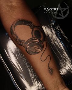 a man with headphones on his arm is shown in black and grey tattoo art