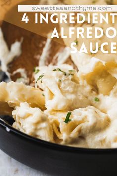 a black bowl filled with alfredo sauce