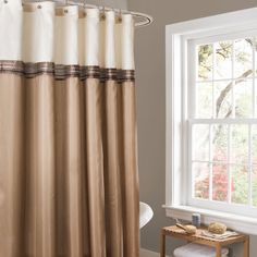 a bathroom with a shower curtain next to a bath tub and window in it's corner