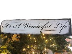 a wooden sign that says it's a wonderful life hanging from a christmas tree