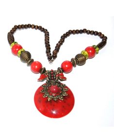 A unique bohemian style necklace. Bohemian Jewelry With Wooden Beads, Bohemian Necklace With Large Pendant, Red Bohemian Necklace With Large Pendant, Bohemian Jewelry With Round Beads For Festive Occasion, Festive Bohemian Beaded Jewelry, Bohemian Round Bead Jewelry For Festivals, Bohemian Round Beads Jewelry For Festivals, Bohemian Necklace With Round Pendant, Large Beads Pendant Necklace