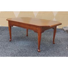 a wooden table sitting on top of a cement ground