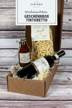 an open box with wine and pasta in it