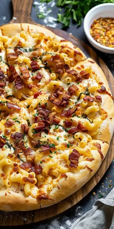 a pizza with bacon, cheese and other toppings sitting on a wooden cutting board