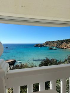 an ocean view from the porch of a house with white railings and blue water