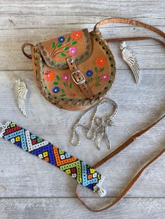 This tiny tooled leather purse has a long shoulder strap and pretty hand-colored flowers.  A souvenir of central Mexico it is fully intact with no loose stitches and in good sturdy condition,  though obviously used and loved.  The strap has an 18 inch drop  and the body of the bag is 4 x 4 x 1 inch Also included with the bag: a pair of silver wing clip on earrings a beaded bracelet a silver-tone wishbone necklace shown on a tiny manaquin. All in good condition and very boho vibe.  I am combining a lot of jewelry and purses for a single price to beat the costs of shipping.  Be sure to look around my shop for more great combos. Multicolor Bohemian Jewelry For Everyday, Multicolor Bohemian Jewelry For Everyday Use, Traditional Handmade Jewelry For Everyday Use, Artisan Hand Tooled Jewelry, Hand Tooled Bohemian Jewelry For Everyday, Bohemian Hand Tooled Jewelry For Everyday Use, Multicolor Hand Tooled Jewelry As Gift, Multicolor Hand Tooled Jewelry Gift, Multicolor Hand Tooled Jewelry For Gifts