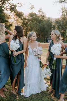 a group of women standing next to each other holding bouquets