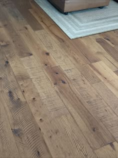 a living room with wood flooring and a rug on the floor in front of it