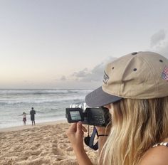 a woman with a camera on the beach