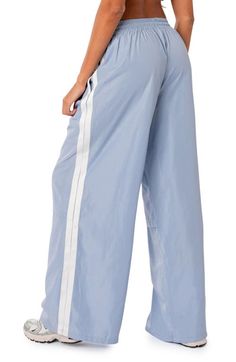 Find EDIKTED Fauna Track Pants on Editorialist. Sporty stripes trail the sides of these wide-leg track pants topped with a comfortable elastic waist. 100% polyester Machine wash, dry flat Imported Street Wear Baggy, Blue Track Pants, Nylon Track Pants, Pants Light Blue, Visionary Fashion, Delivery Bag, Blue Trousers, Nylon Fabric, Athletic Pants