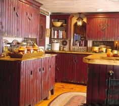 an old fashioned kitchen with red cabinets and wood flooring is pictured in this image