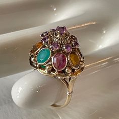 This Art Nouveau Ring Isn't Like Anything We've Seen Before. A Beautiful 14k Gold, Detailed Band Supports An Overstated Setting. The Main Setting Features 9 Small Garnet, And 8 Large Stones Consisting Of; Blue Sapphire, Citrine, Emerald, Ruby, Tiger's Eye, Topaz, Tourmaline, And White Sapphire. Ring Size Is 7 3/4. Weighs 6.8g. Measures 34.925 Mm In Height (Base Of Band To Top Of Setting), 22.225 Mm In Width, 79.756 Mm Circumference. If You Have Any Questions, We Are More Than Happy To Help! Multicolor Cabochon Rings In Fine Jewelry Style, Multicolor Cabochon Rings Fine Jewelry, Fine Jewelry Multicolor Cabochon Gemstones, Multicolor Cabochon Gemstones Fine Jewelry, Multicolor Cabochon Gemstones For Fine Jewelry, Luxury Multi-stone Pink Gemstones, Luxury Pink Multi-stone Gemstones, Elegant Multicolor Ruby Ring, Elegant Multicolor Cabochon Rings