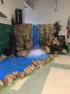 an indoor waterfall with blue water and rocks