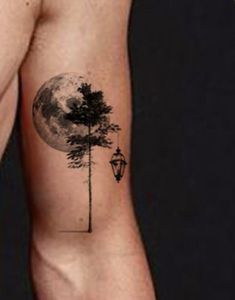 a man with a tree and street light tattoo on his arm