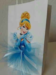 a paper bag with a drawing of a princess on the front and blue tulle skirt