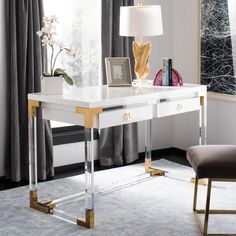 a white and gold desk in a room with grey curtains on the window sill