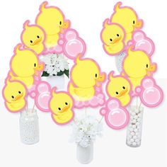 a bunch of little ducks sitting on top of vases filled with white and pink flowers