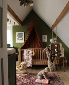 a baby is playing on the floor in a room with green walls and white ceiling