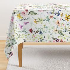 a table with a floral print on it and a white rug in front of it