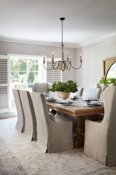 a dining room table with chairs and a chandelier