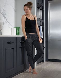 a woman is standing in the kitchen holding an apple