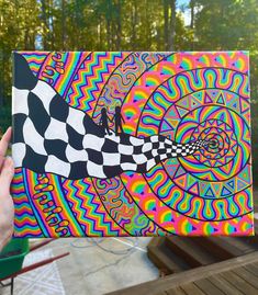 a person holding up a piece of art that looks like a fish with a checkered design on it