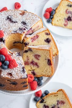 a bundt cake with berries and powdered sugar on top is cut in half