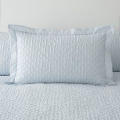 two white pillows sitting on top of a bed