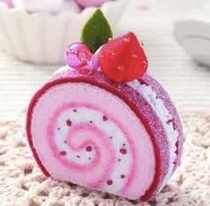 a pink and white spiral shaped object on top of a rug next to cupcakes