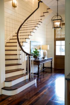 a wooden floor sitting under a stair case next to a light on a lamp post