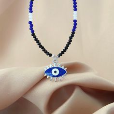 This whimsical piece combines the earthy charm of a beaded necklace with the mystic allure of gemstone jewelry, creating a unique and sparkly accessory. The intricate beads, add a touch of spirituality to your ensemble. The evil eye pendant, a symbol of protection, takes center stage, warding off negative vibes with its watchful gaze. Wear this enchanting necklace not just as a fashion statement, but as a talisman that blends style and spiritual significance in one harmonious accessory W H Y  _ I'M _  S P E C I A L 📿 Handmade  to Order from a small business  🤗Meticulously handcrafted with tiny glittering, shining, crystal beads 🧿 Evil Eye Protection Charm 💦 Waterproof  🌟 Lightweight  🛡️ Hypoallergenic ️Statement,elegant, perfect for everyday wear or for special occasions 🛩️ Fast shi Spiritual Pendant Necklaces With Beaded Chain, Spiritual Pendant Necklace With Beaded Chain, Spiritual Beaded Dangle Necklaces For Gifts, Spiritual Beaded Pendant Jewelry, Beaded Pendant Charm Necklace Gift, Symbolic Gemstone Bead Necklaces For Gifts, Beaded Amulet Necklace As Gift, Beaded Pendant Charm Necklace For Gift, Gift Beaded Pendant Charm Necklaces