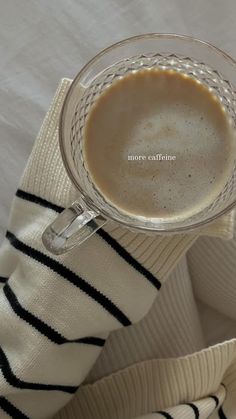 a cup of coffee sitting on top of a white blanket