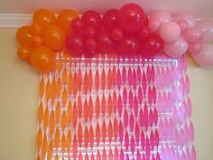 an assortment of balloons and streamers on a wall