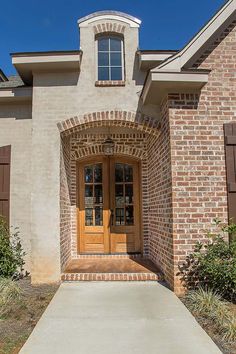 the front entrance to a home with brick and wood shutters