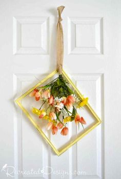 a door hanger with flowers hanging from it's side on a white door