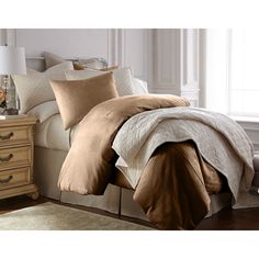 a bed with brown and white comforters in a bedroom