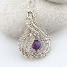 This wire-woven pendant is handmade and wrapped in 925 Sterling Silver wire with a gorgeous faceted Ametrine gemstone. It has a graceful, circular design and comes with a solid 18 inch 925 Sterling Silver ball chain. It makes a wonderful gift for a spiritual person. This design is handmade using a Nicole Hanna tutorial with some variations. Ametrine is a variety of quartz. It is a mixture of Amethyst and Citrine and combines the healing properties of both. It relieves stress, allows for spiritua Luxury Oval Wire Wrapped Necklace, Spiritual Person, Amethyst And Citrine, Wire Wrapped Gemstones Pendant, Sterling Silver Wire Wrap, Circular Design, Jewelry Unique, Unique Pendant, Ball Chain