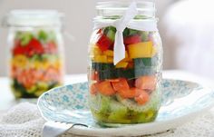 a glass jar filled with sliced vegetables on top of a plate