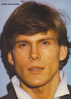 a close up of a person wearing a suit and white shirt with hair in the wind