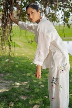 Ivory top with floral applique placement embroidery.
Component: 1
Pattern: Embroidery
Type Of Work: Floral
Neckline: Round
Sleeve Type: Long sleeves
Fabric: Gauze linen
Color: Ivory
Other Details: 
Front button detailing
Note: Pant worn by the model is not for sale
Occasion: Party - Aza Fashions White Floral Embroidered Tops For Wedding, Cotton Embroidered Top With Floral Design For Weddings, Floral Embroidered Top For Summer Wedding, White Floral Embroidery Top For Garden Party, White Sets With Intricate Embroidery For Spring, Summer Floral Embroidered Top For Wedding, Cream Embroidered Top With Chikankari For Spring, Spring Off-white Embroidered Top With Floral Design, Spring Off White Embroidered Top With Floral Embroidery