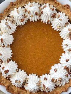 a pie with white frosting and pecans on top