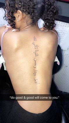 the back of a woman's body with writing on her upper and lower back