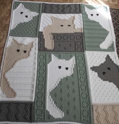 a crocheted blanket with several cats on it, all in different colors and sizes