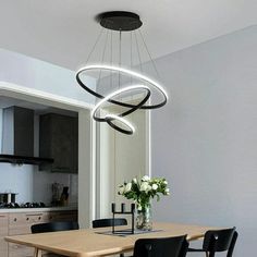 a dining room table with four chairs and a chandelier hanging from the ceiling