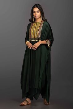 Forest green kaftan style kurta with Ajrakh embroidery and coin embellishments. Comes with dhoti pants.
Components:2
Embroidered
Neckline:Round
Sleeve Length:Three Quarter
Fabric:Satin Silk
Color:Green
Asymmetrical kurta hemline
Side slits
Sleeves with embroidered hems and button closure
Keyhole back with hook closure - Aza Fashions Green Kaftan, Kaftan Kurta, Kurta Patterns, Simple Kurta Designs, Dhoti Pants, Kaftan Style, Silk Kaftan, Kurta Designs Women, Stylish Party Dresses