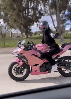 a person riding on the back of a pink motorcycle