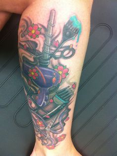 a tattoo on the leg of a person with scissors and other items in it's hand